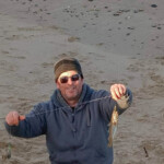 Paul Denholm with a whiting. Picture shows how high the drop is from top of sand dune Paul Denholm with a whiting